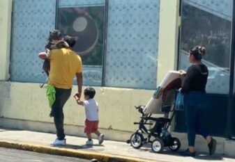 Video of Man Carrying Dog While Walking with Kid