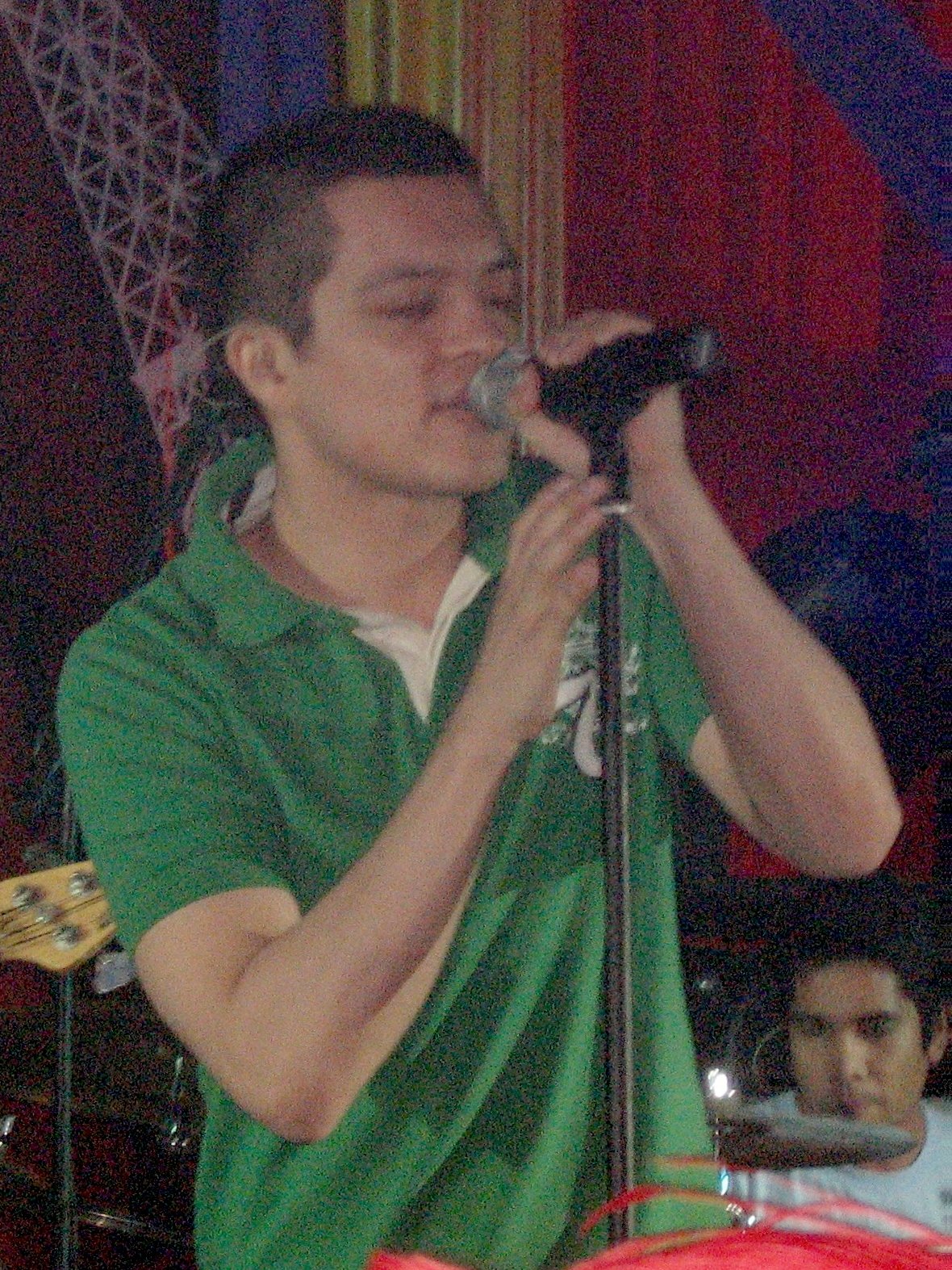 OPM singer Bamboo Mañalac singing into a microphone on stage