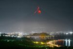 Mayon Volcano glowing at night above city lights in Albay