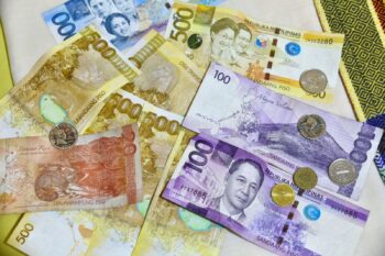 Philippine peso banknotes and coins spread on a table