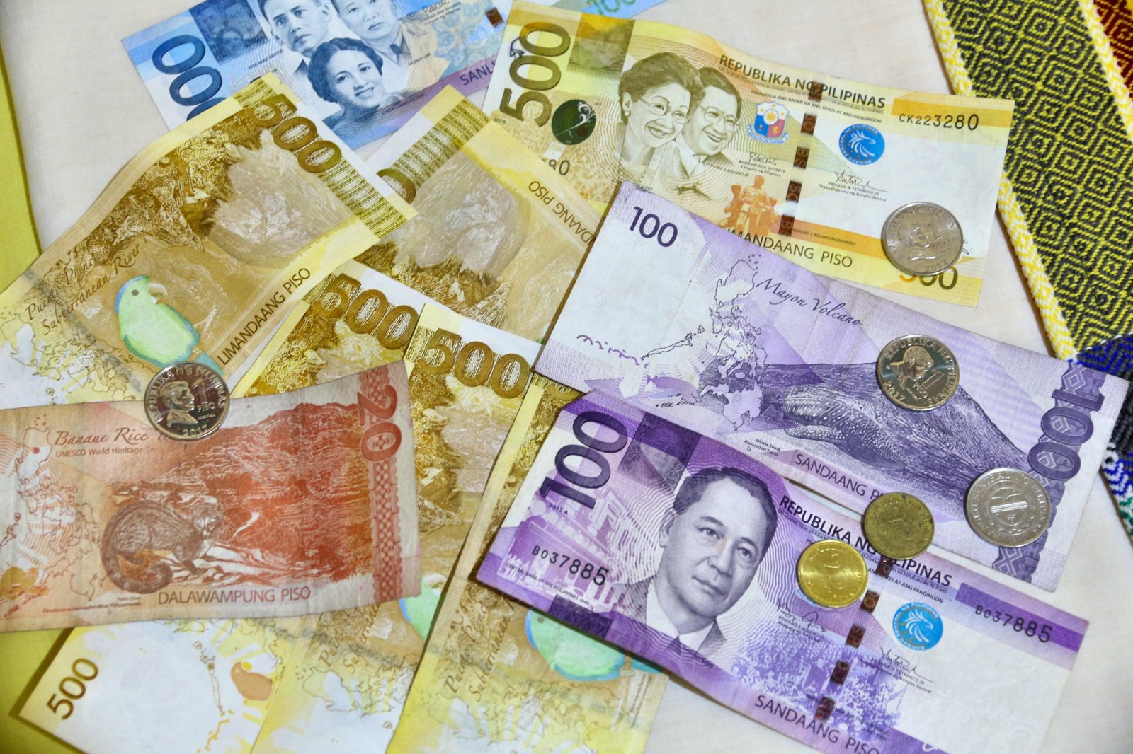 Philippine peso banknotes and coins spread on a table