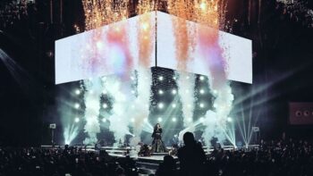 Regine Velasquez performing on a concert stage with pyrotechnics and stage lights