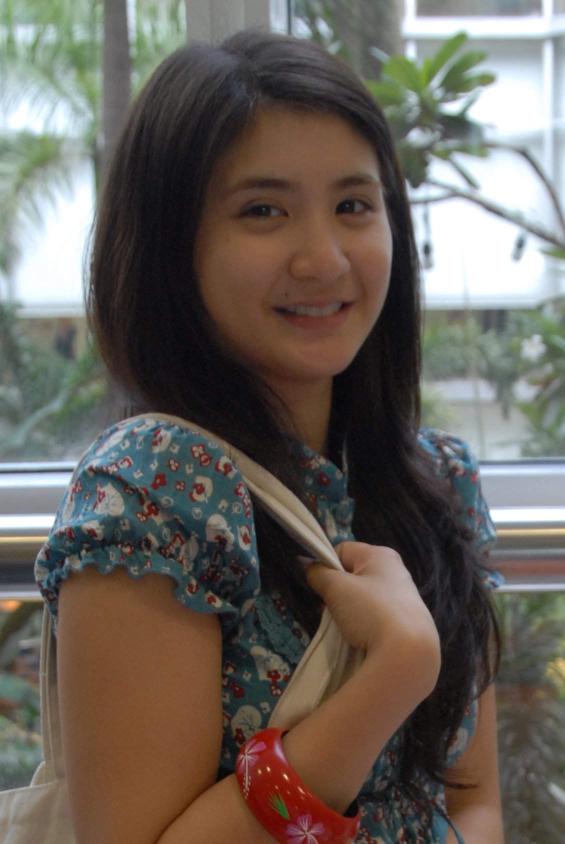 Actress Rica Peralejo smiling in a floral blouse while carrying a tote bag