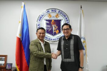 Education Secretary Sonny Angara shaking hands with Sen. Bam Aquino in front of the Department of Education seal