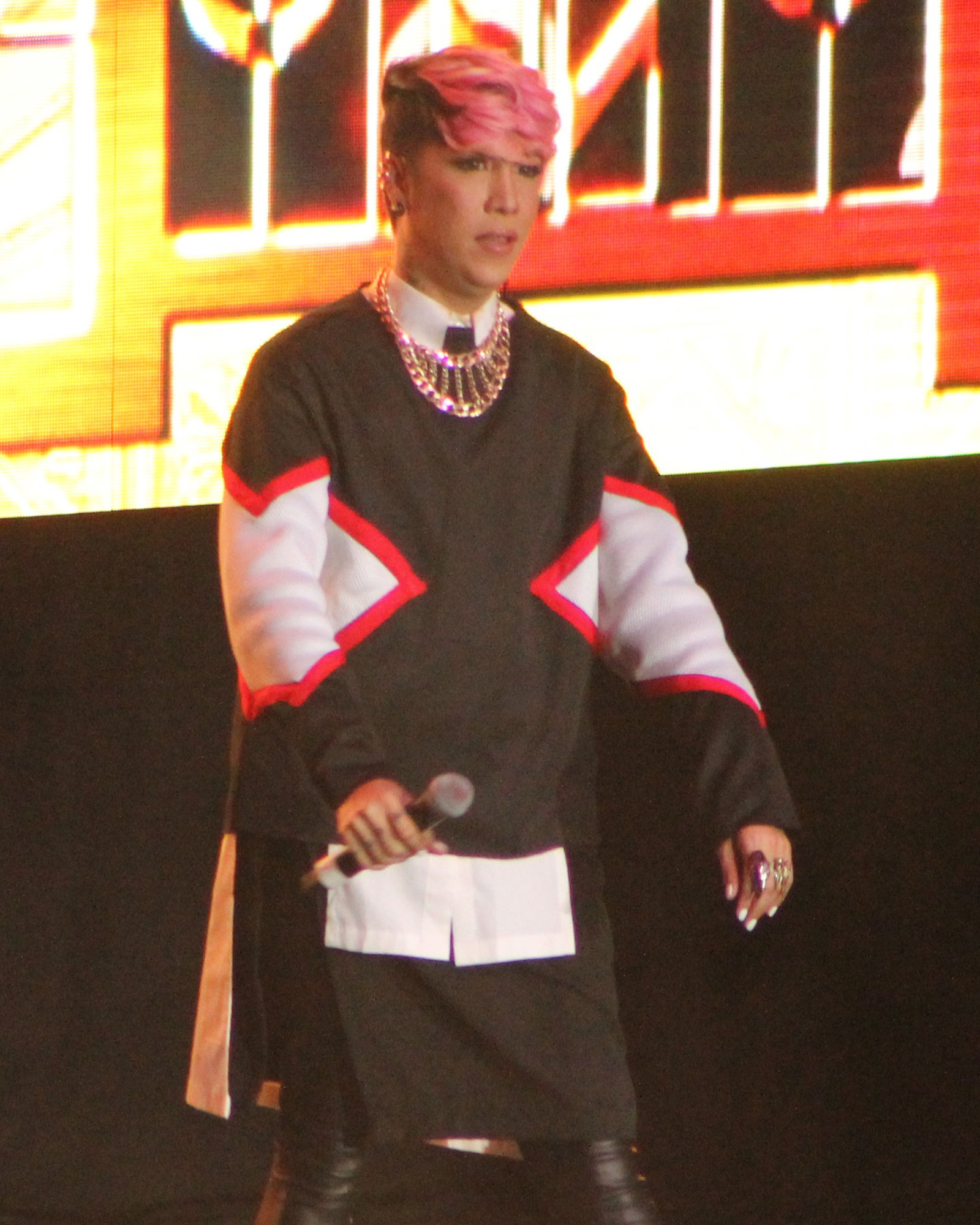 Vice Ganda with pink hair performing on stage holding a microphone